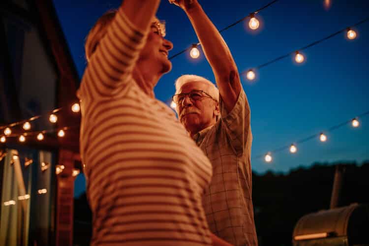 14 Free Ways to Help Your Brain Find Happiness Right Now - Older couple dancing under night sky and twinkle lights