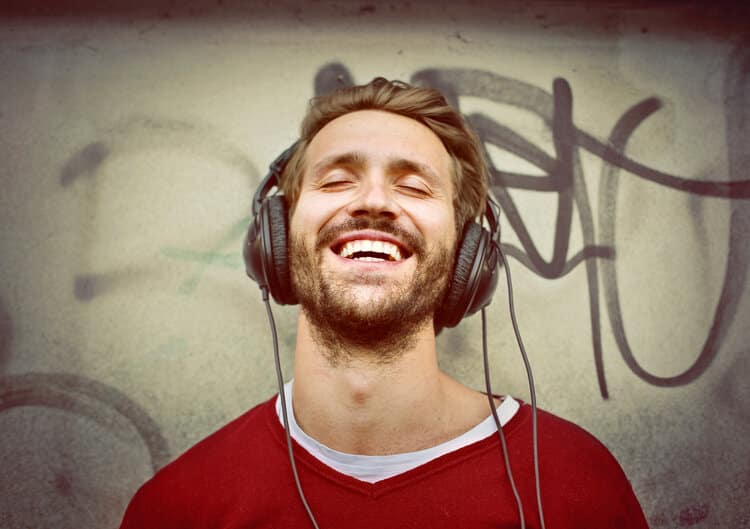 14 Free Ways to Help Your Brain Find Happiness Right Now - man with headphones on eyes closed smiling