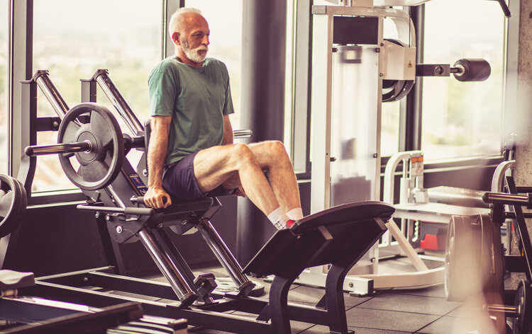 This Is How Strong Muscles Make Your Brain Stronger - mature man on machine working legs.